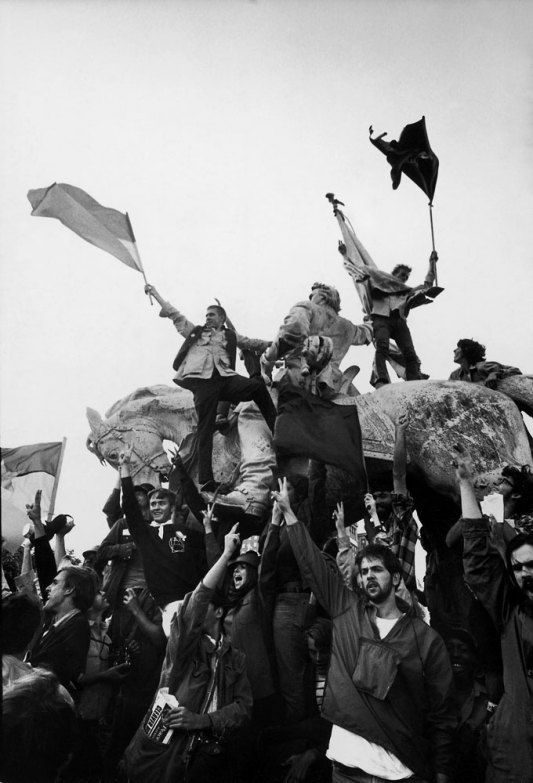 Crowd with flags raised over a monument